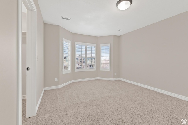 spare room with visible vents, baseboards, and carpet floors