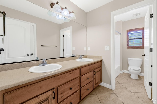bathroom featuring toilet, tile patterned floors, double vanity, and a sink