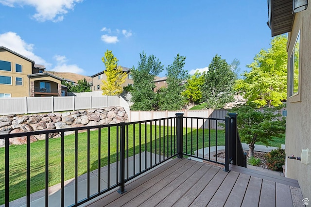 wooden deck with a yard, a fenced backyard, and a residential view