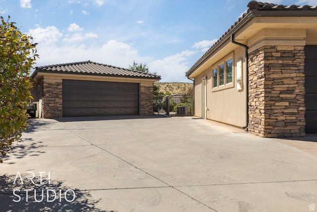 1285 Summerwood Cir, Santa Clara, UT 84765 - view of side of home with a garage, central AC, stone siding, and a tile roof