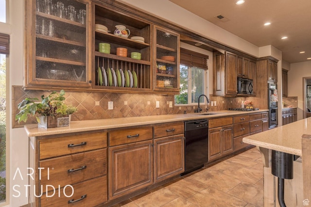 1285 Summerwood Cir, Santa Clara, UT 84765 - kitchen with glass insert cabinets, backsplash, black appliances, visible vents, and a sink