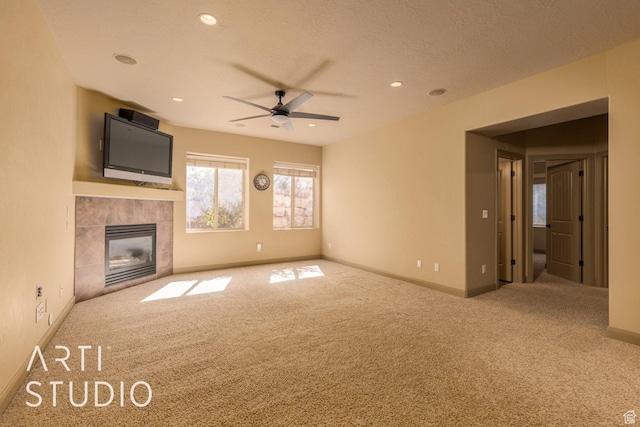 1285 Summerwood Cir, Santa Clara, UT 84765 - unfurnished living room with baseboards, a tiled fireplace, a textured ceiling, a ceiling fan, and carpet floors