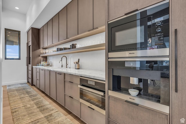 2178 E Lone Peak Ln, Kamas, UT 84036 - kitchen featuring light wood-style flooring, a sink, double oven, decorative backsplash, and light stone counters