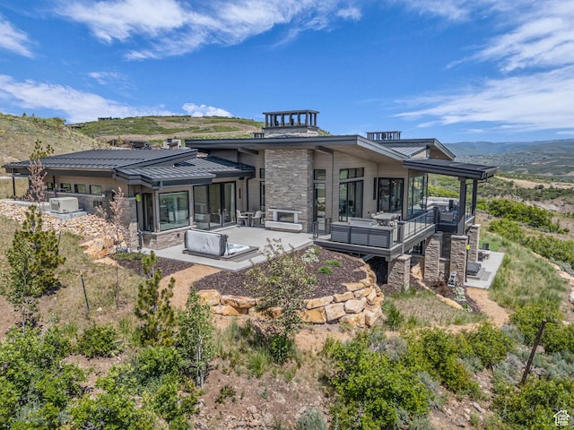 2178 E Lone Peak Ln, Kamas, UT 84036 - back of property featuring stone siding, a standing seam roof, a mountain view, a patio area, and metal roof