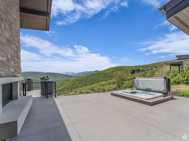 2178 E Lone Peak Ln, Kamas, UT 84036 - view of patio / terrace featuring a covered hot tub, a mountain view, an outdoor stone fireplace, and area for grilling