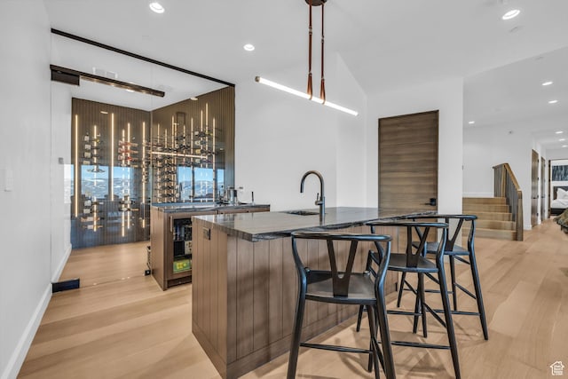2178 E Lone Peak Ln, Kamas, UT 84036 - kitchen featuring a sink, dark countertops, light wood finished floors, and a center island with sink