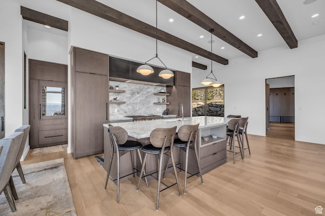 2178 E Lone Peak Ln, Kamas, UT 84036 - kitchen with modern cabinets, a kitchen breakfast bar, light wood-style flooring, tasteful backsplash, and open shelves