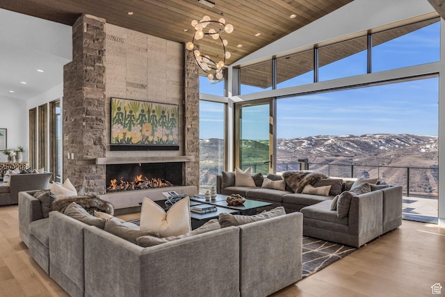 2178 E Lone Peak Ln, Kamas, UT 84036 - living area featuring expansive windows, a mountain view, a fireplace, wood ceiling, and wood finished floors
