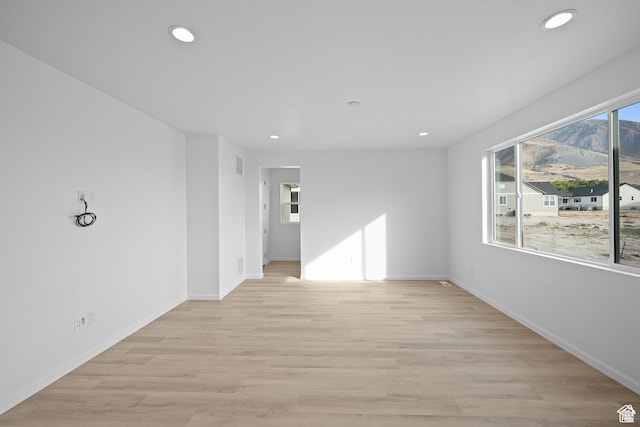 unfurnished room with light wood-style flooring, baseboards, and recessed lighting