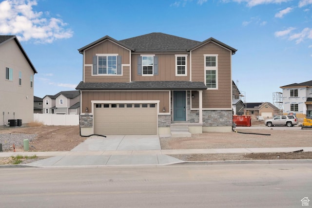 2067 E Antonio Dr N Unit 1230, Lake Point, UT 84074 - view of front of house featuring board and batten siding, stone siding, driveway, and a garage