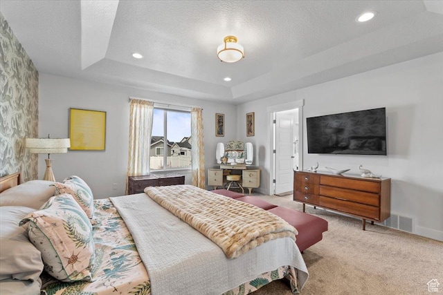 carpeted bedroom with a raised ceiling, a textured ceiling, baseboards, and visible vents