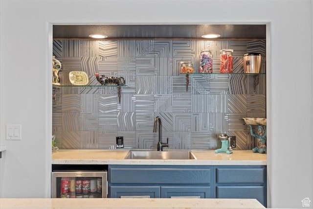 interior space with indoor wet bar, a sink, light countertops, wine cooler, and blue cabinets