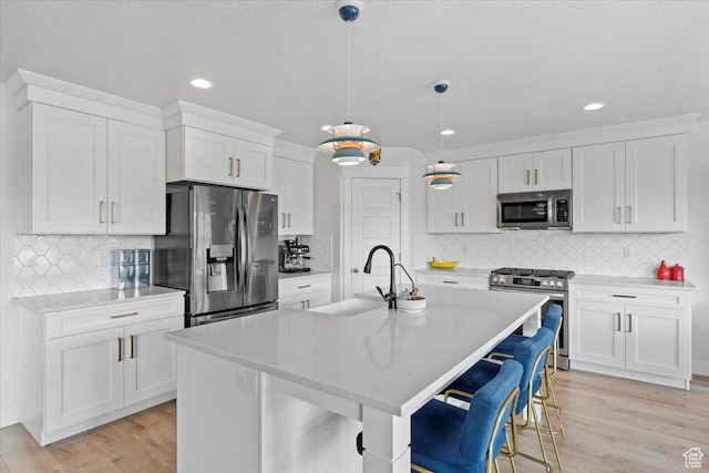 kitchen with a sink, light countertops, white cabinetry, and stainless steel appliances