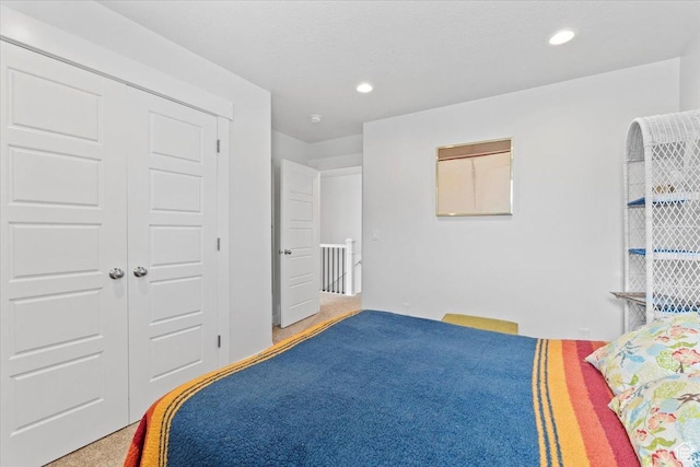 bedroom with a closet, recessed lighting, and carpet flooring