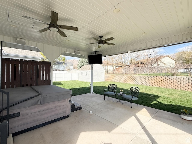 view of patio / terrace featuring a hot tub, a ceiling fan, a fenced backyard, a storage unit, and an outbuilding