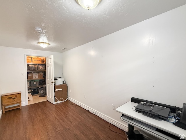 office area with dark wood-style flooring, baseboards, and a textured ceiling