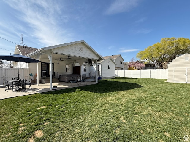 rear view of house featuring fence, a patio, a lawn, and a ceiling fan