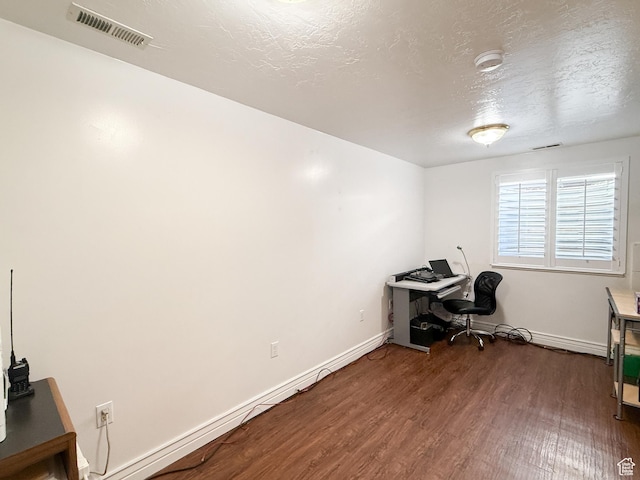 office area featuring visible vents, baseboards, a textured ceiling, and dark wood finished floors