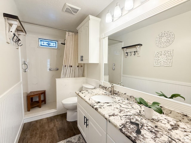 full bath with visible vents, a shower with curtain, and a wainscoted wall