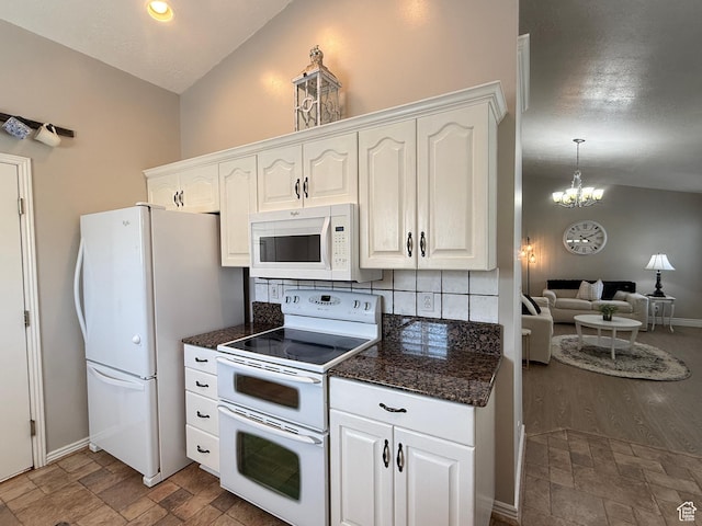 kitchen with white cabinets, white appliances, an inviting chandelier, and lofted ceiling