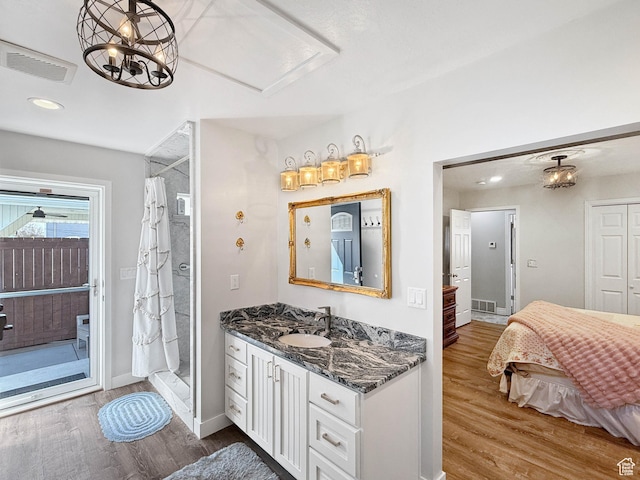 full bathroom with vanity, wood finished floors, a shower with curtain, and visible vents