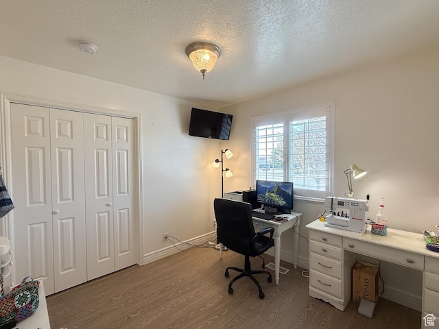 office space featuring baseboards, wood finished floors, and a textured ceiling