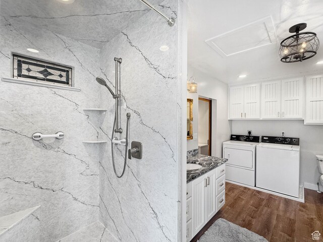 interior space featuring dark wood-type flooring, white cabinets, washing machine and dryer, and dark stone counters