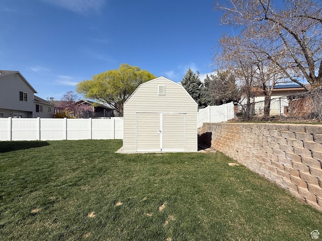 view of yard featuring a shed, a fenced backyard, and an outdoor structure