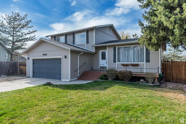 tri-level home with a front lawn, fence, a garage, and concrete driveway