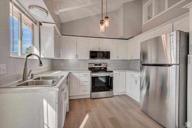 kitchen with stainless steel appliances, white cabinets, and a sink