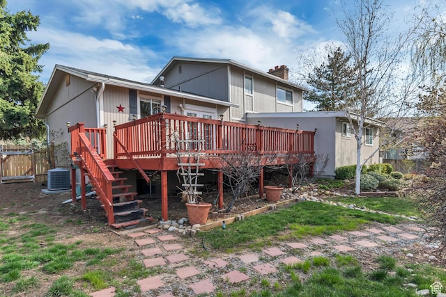 rear view of property with central air condition unit, a chimney, stairway, a deck, and fence