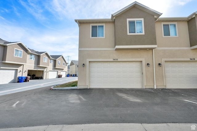 3632 E Sapphire Creek Ln N Unit 318, Eagle Mountain, UT 84005 - view of property with stucco siding, a residential view, and a garage
