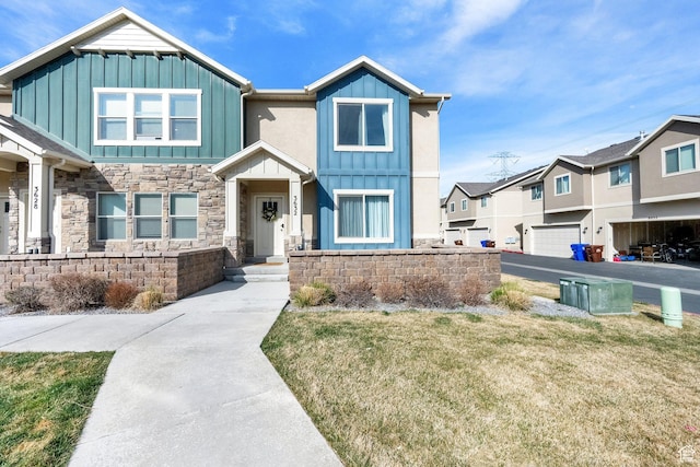 craftsman-style house featuring a front lawn, stone siding, and board and batten siding