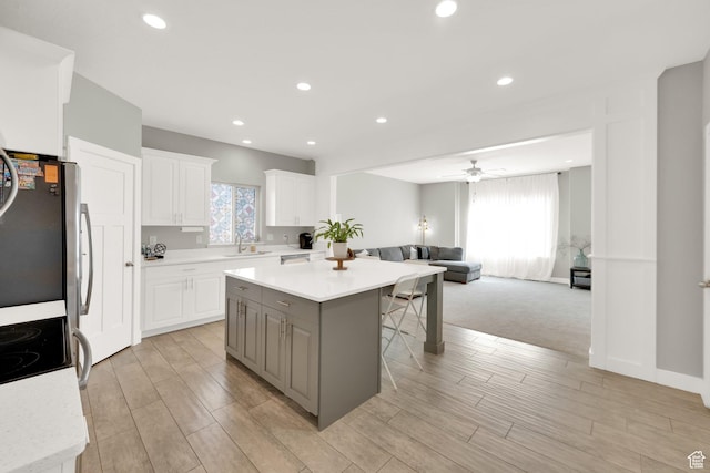 3632 E Sapphire Creek Ln N Unit 318, Eagle Mountain, UT 84005 - kitchen with light countertops, a ceiling fan, a center island, a kitchen bar, and open floor plan