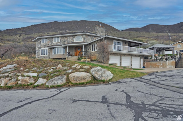 360 E 1825 N, Centerville, UT 84014 - view of front facade featuring a mountain view, stone siding, a garage, and concrete driveway