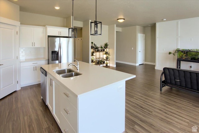 kitchen featuring a sink, light countertops, a center island with sink, and stainless steel appliances