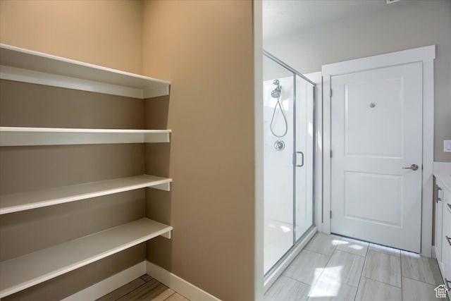 bathroom featuring baseboards and a shower stall