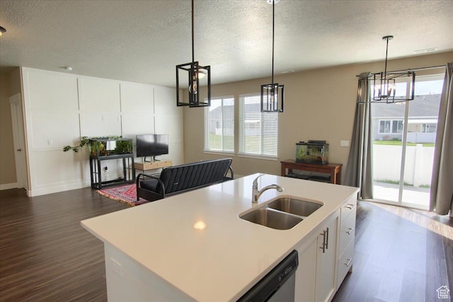 kitchen featuring dark wood-type flooring, a notable chandelier, light countertops, and a sink