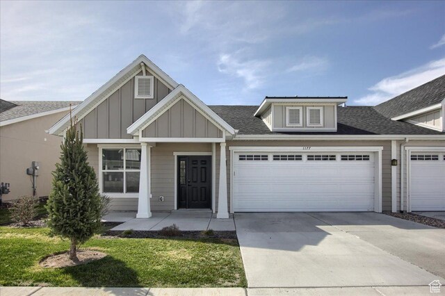 view of front of home featuring a garage, roof with shingles, driveway, and board and batten siding