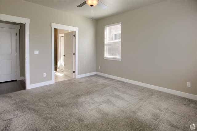 unfurnished bedroom with ceiling fan, light colored carpet, and baseboards