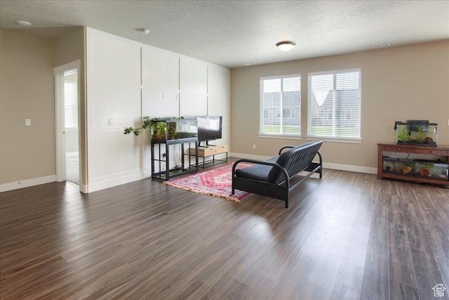 sitting room featuring dark wood-type flooring, a textured ceiling, baseboards, and visible vents