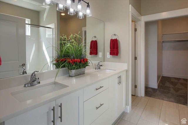 full bath featuring a sink, a spacious closet, double vanity, and a shower with shower door