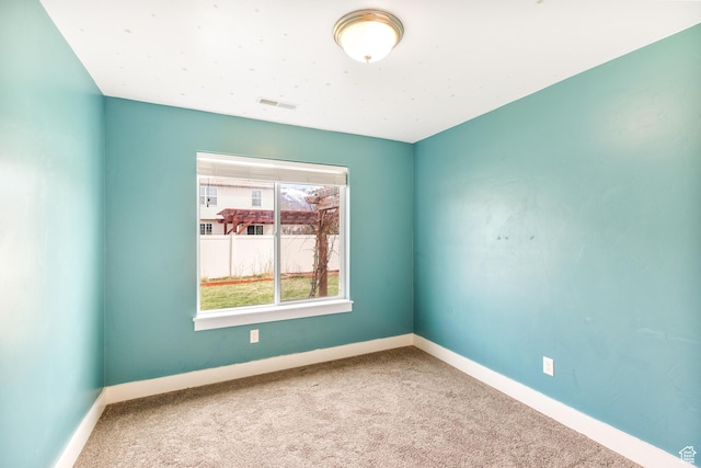 carpeted spare room with baseboards and visible vents
