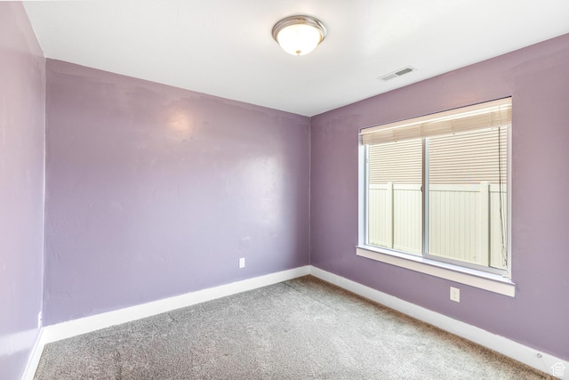 carpeted empty room featuring visible vents and baseboards