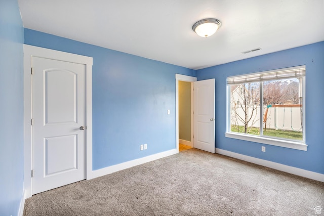 unfurnished bedroom featuring visible vents, baseboards, and carpet flooring