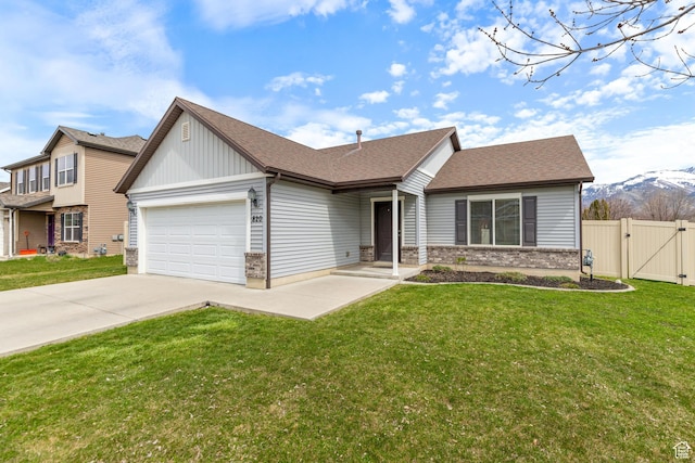 ranch-style home with concrete driveway, a gate, an attached garage, a front yard, and fence