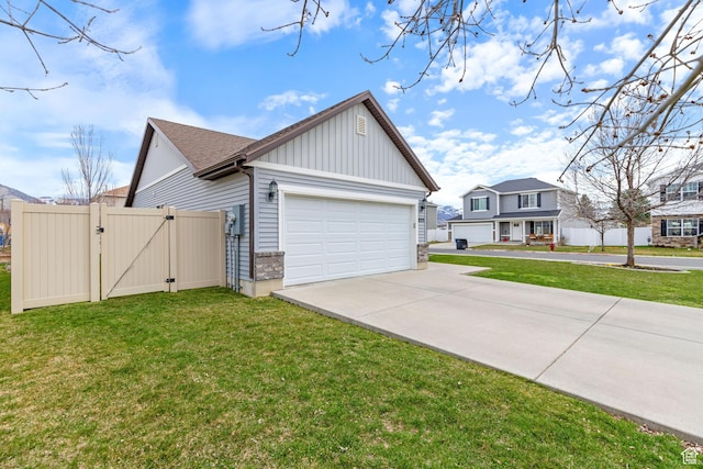 view of property exterior featuring driveway, board and batten siding, an attached garage, a yard, and a gate