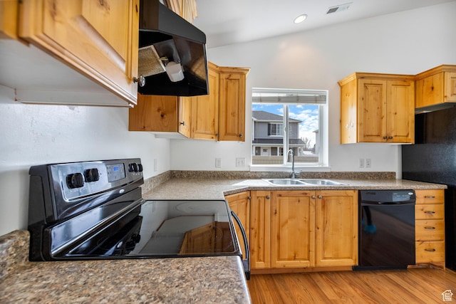 kitchen with black appliances, visible vents, light wood finished floors, range hood, and a sink