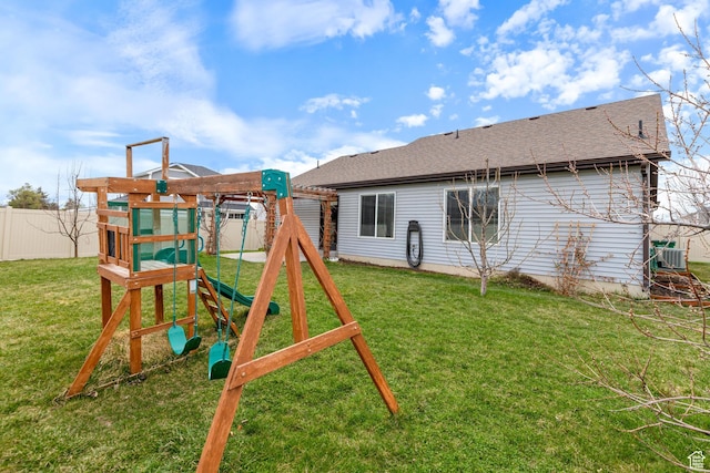 view of play area featuring a yard, fence, and central AC