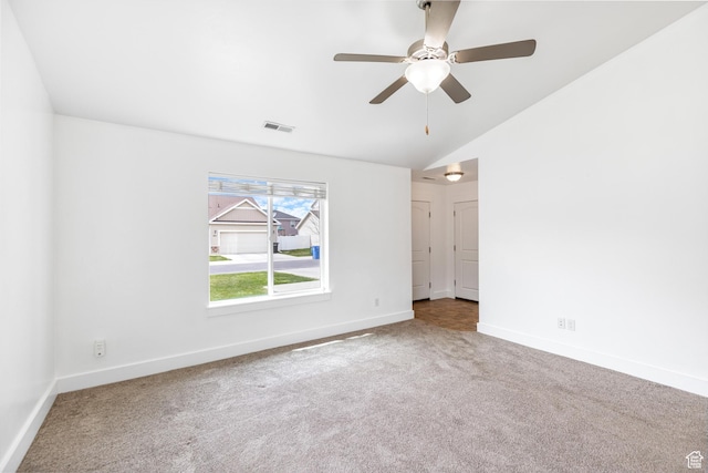 carpeted empty room featuring visible vents, baseboards, a ceiling fan, and vaulted ceiling